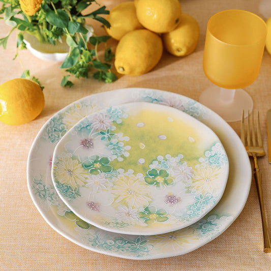 Stacked Watercolor Meadow plates in green and pastel florals styled with lemons and amber goblets, table scene.