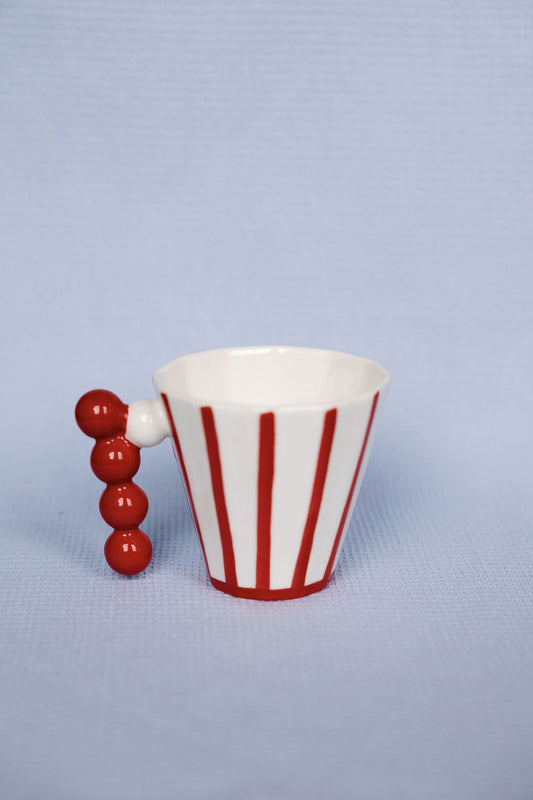 Red and white striped cup with a handle on a light blue background