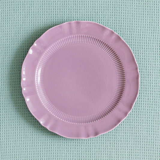 Mauve Provence Pleated porcelain plate with ribbed band and scalloped edge on a pale green waffle cloth.