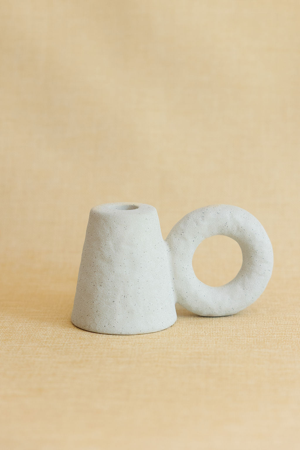 one white ceramic candle holder on a beige background
