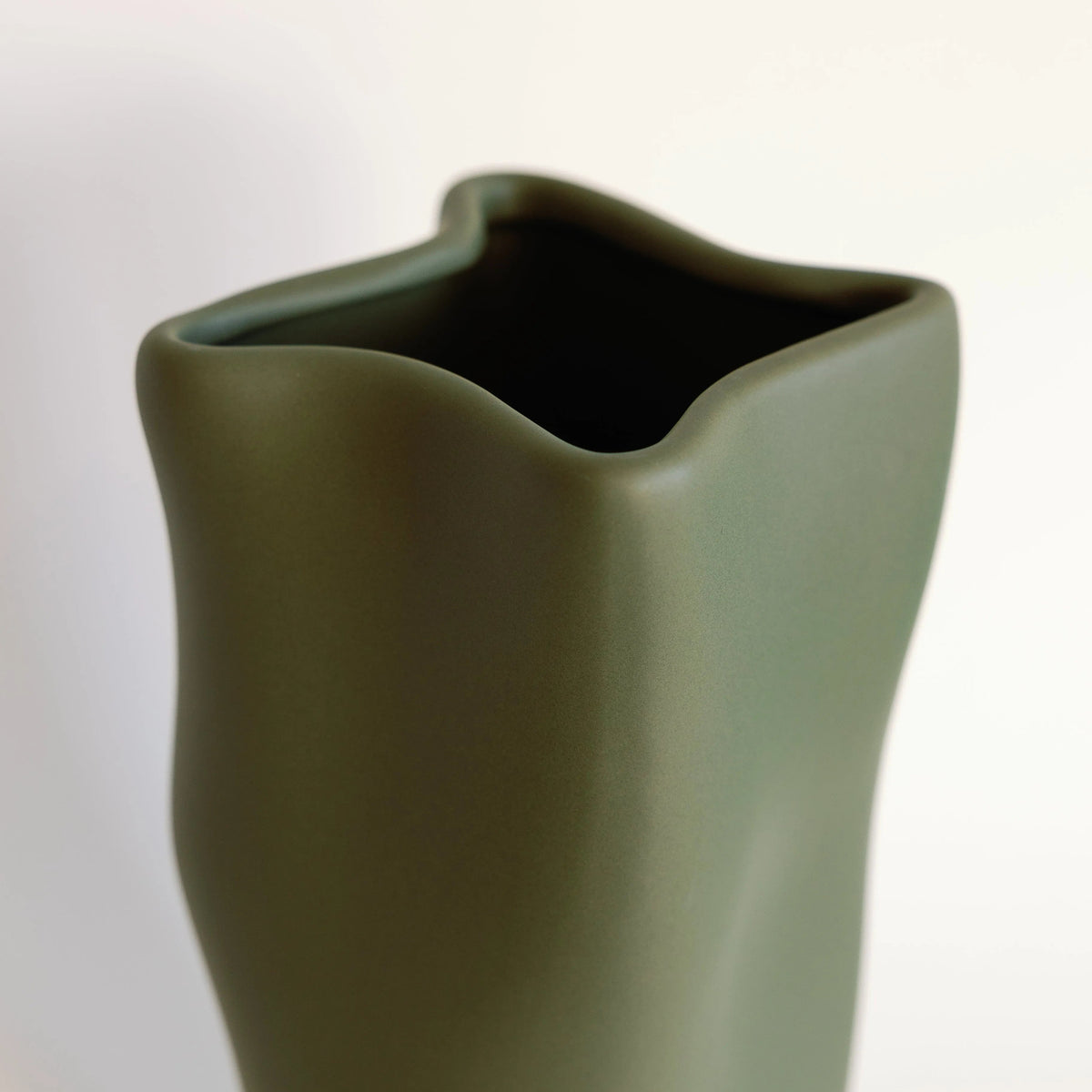 Olive green ripple vase close-up on the curved scalloped rim and open mouth