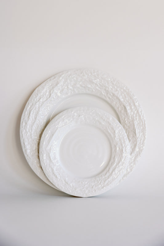 Two white Alpine Snow porcelain plates with rough textured rims stacked in two sizes against a soft white backdrop.