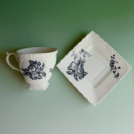 Teacup and saucer with floral design on a green background