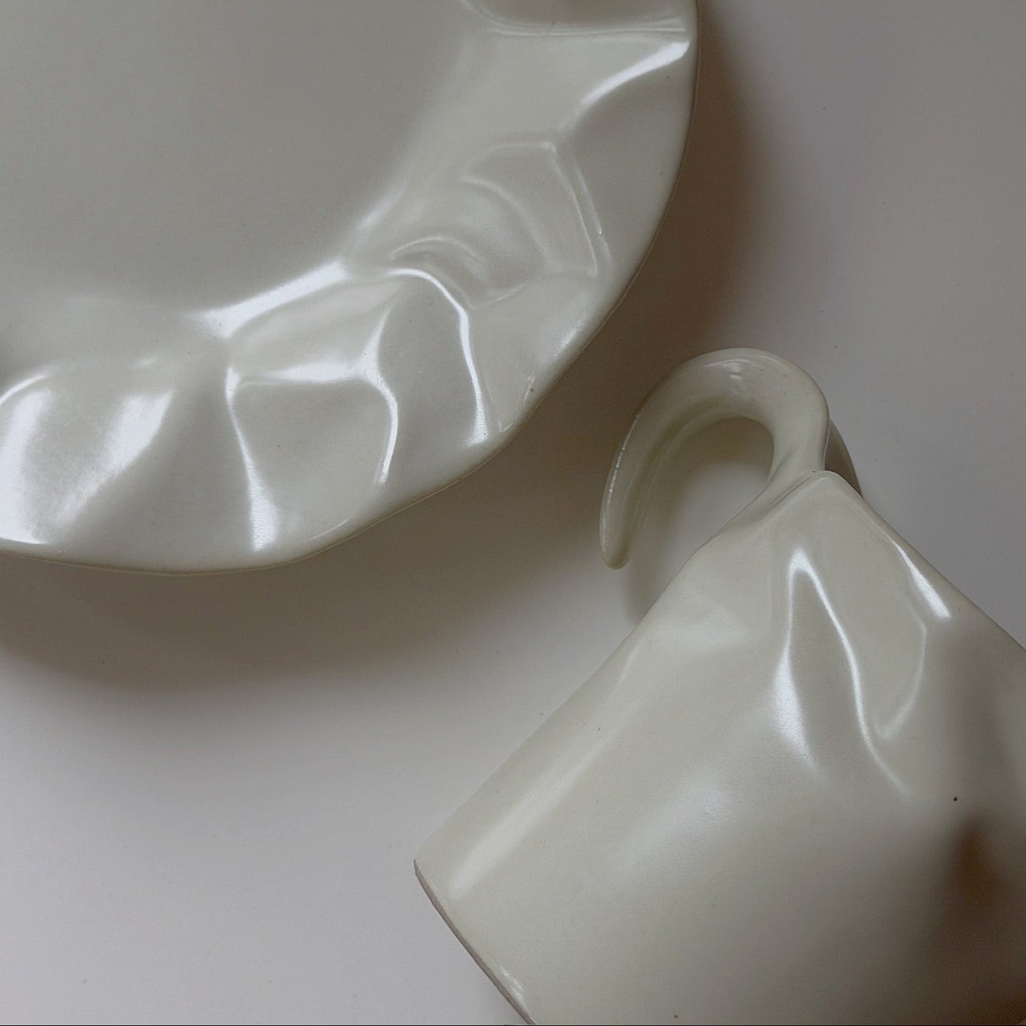 White porcelain tea cup and saucer on a light gray background