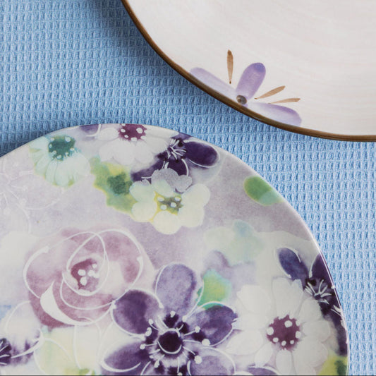 Two ceramic plates with floral designs on a blue textured surface