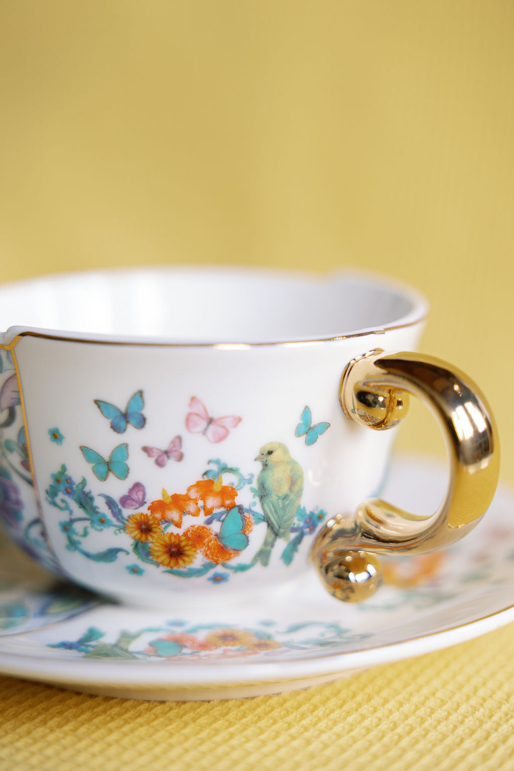 Paradise porcelain tea cup and saucer with gold gilded handle and tropical floral pattern