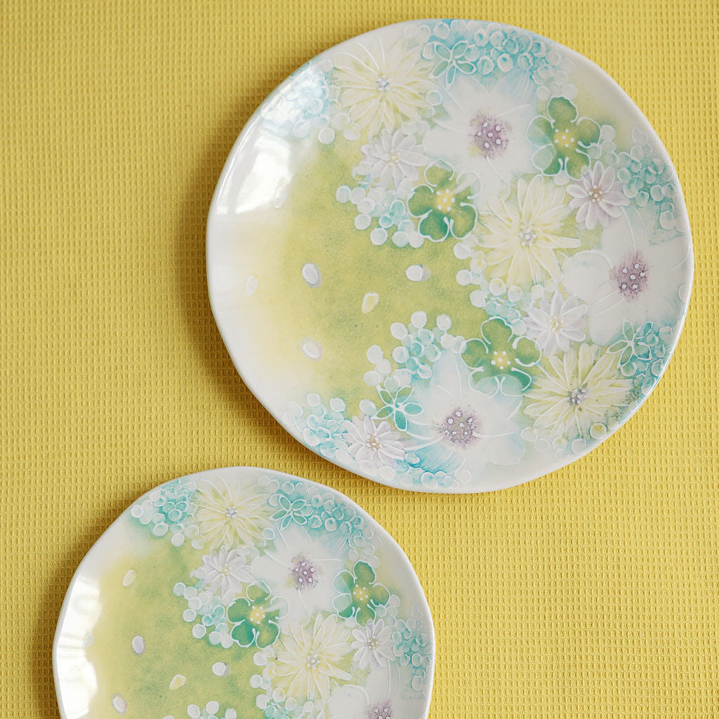 Watercolor meadow dinner plates layered with matching salad plates in pastel floral pattern, full place setting