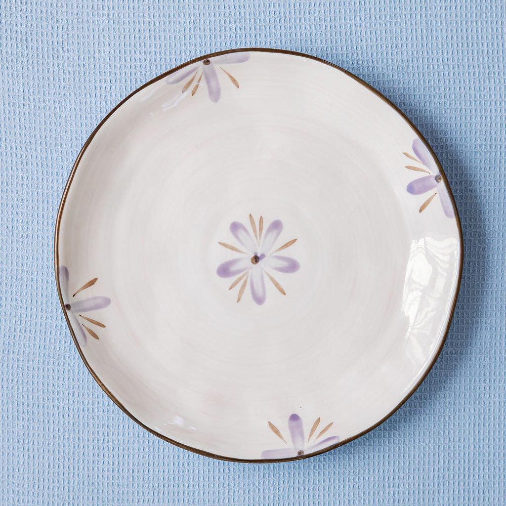Decorative ceramic plate with floral patterns on a blue textured background