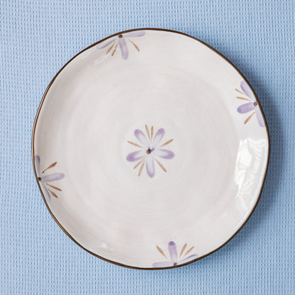 Decorative ceramic plate with floral patterns on a blue textured background
