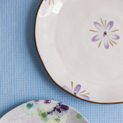 Two ceramic plates with floral designs on a blue textured surface