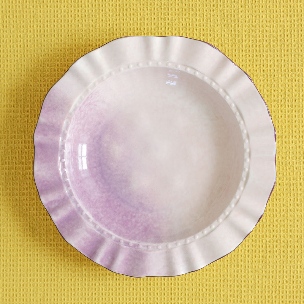 White ceramic bowl with purple gradient on a yellow textured background
