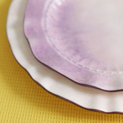 Close-up of a ceramic plate with a purple interior on a yellow textured surface