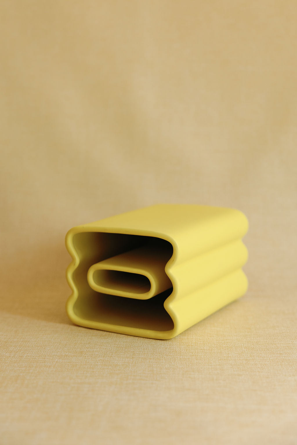Yellow textured fabric roll on a beige background