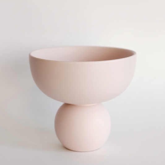 Sophie Ceramic Vase in blush pink, pedestal compote bowl on a round ball base against a neutral backdrop.