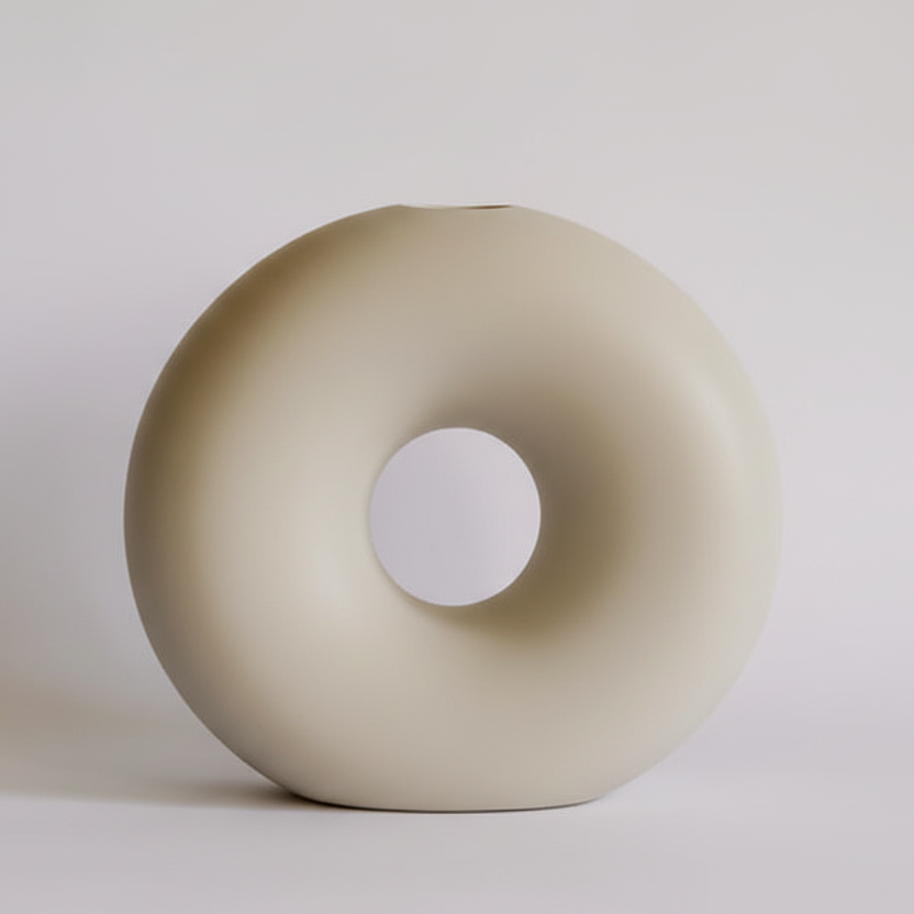 Beige donut-shaped object on a light gray background