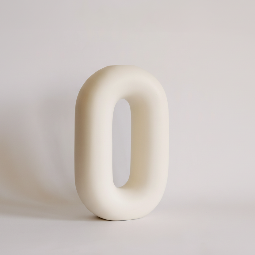 white ceramic loop vase on grey background