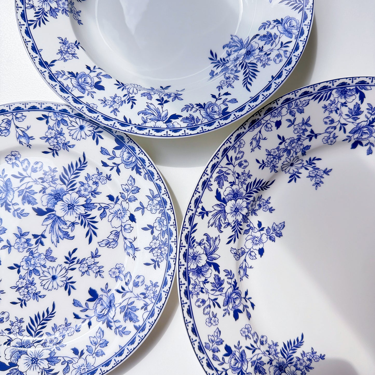 Set of white plates with blue floral patterns on a white background