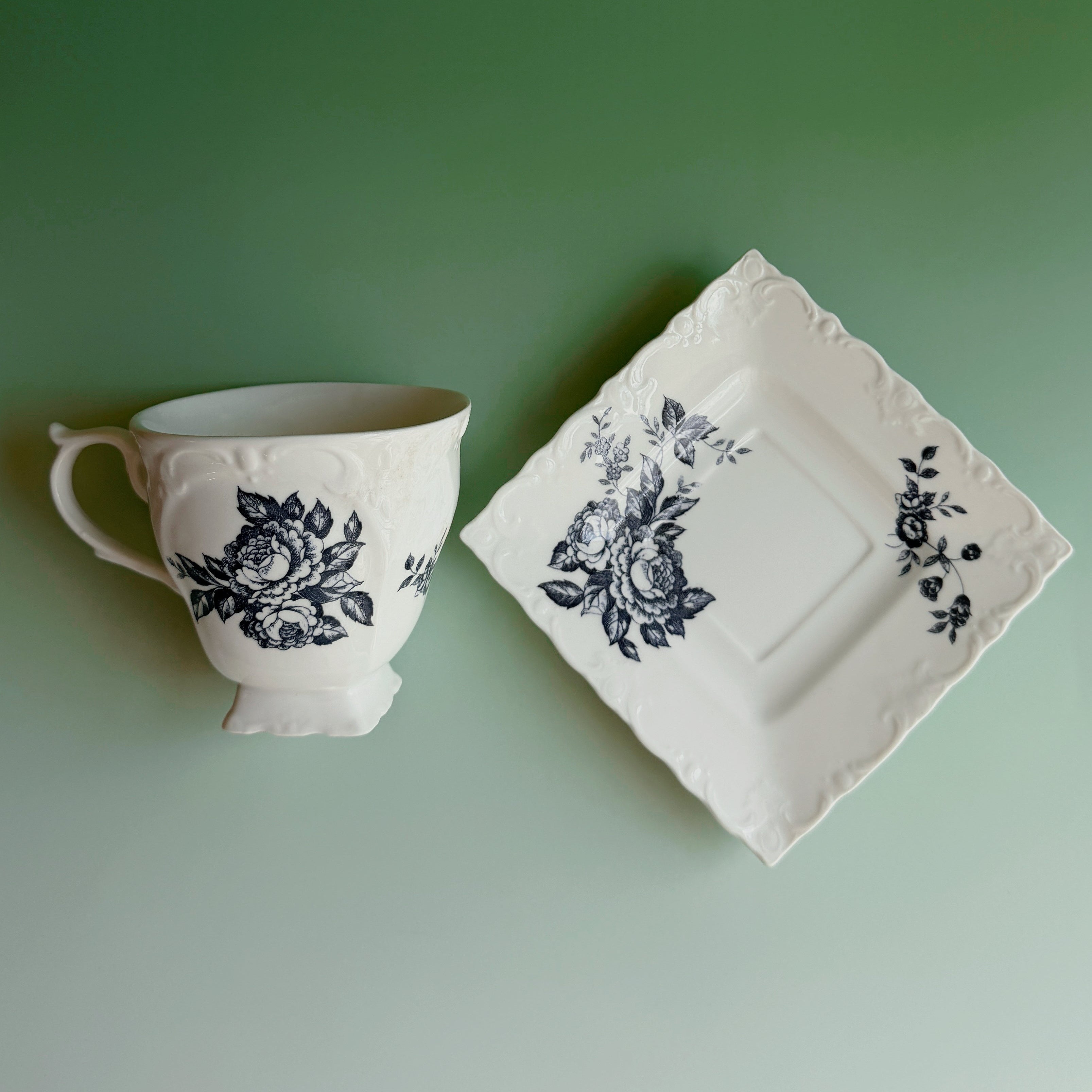 Teacup and saucer with floral design on a green background
