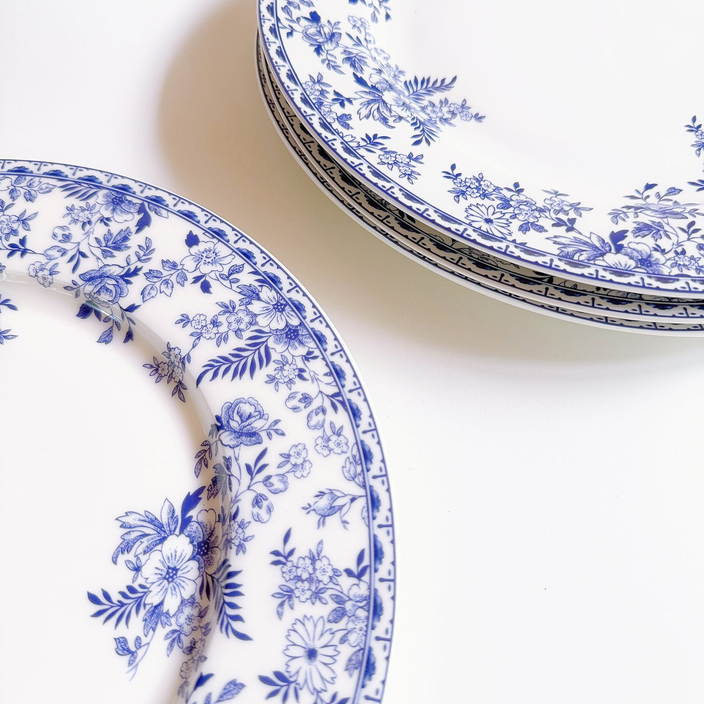 Blue floral patterned plates on a white surface