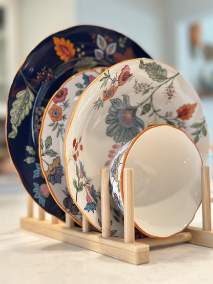 Azure Desert Floral plates and bowls in navy and floral prints displayed on a wooden rack.