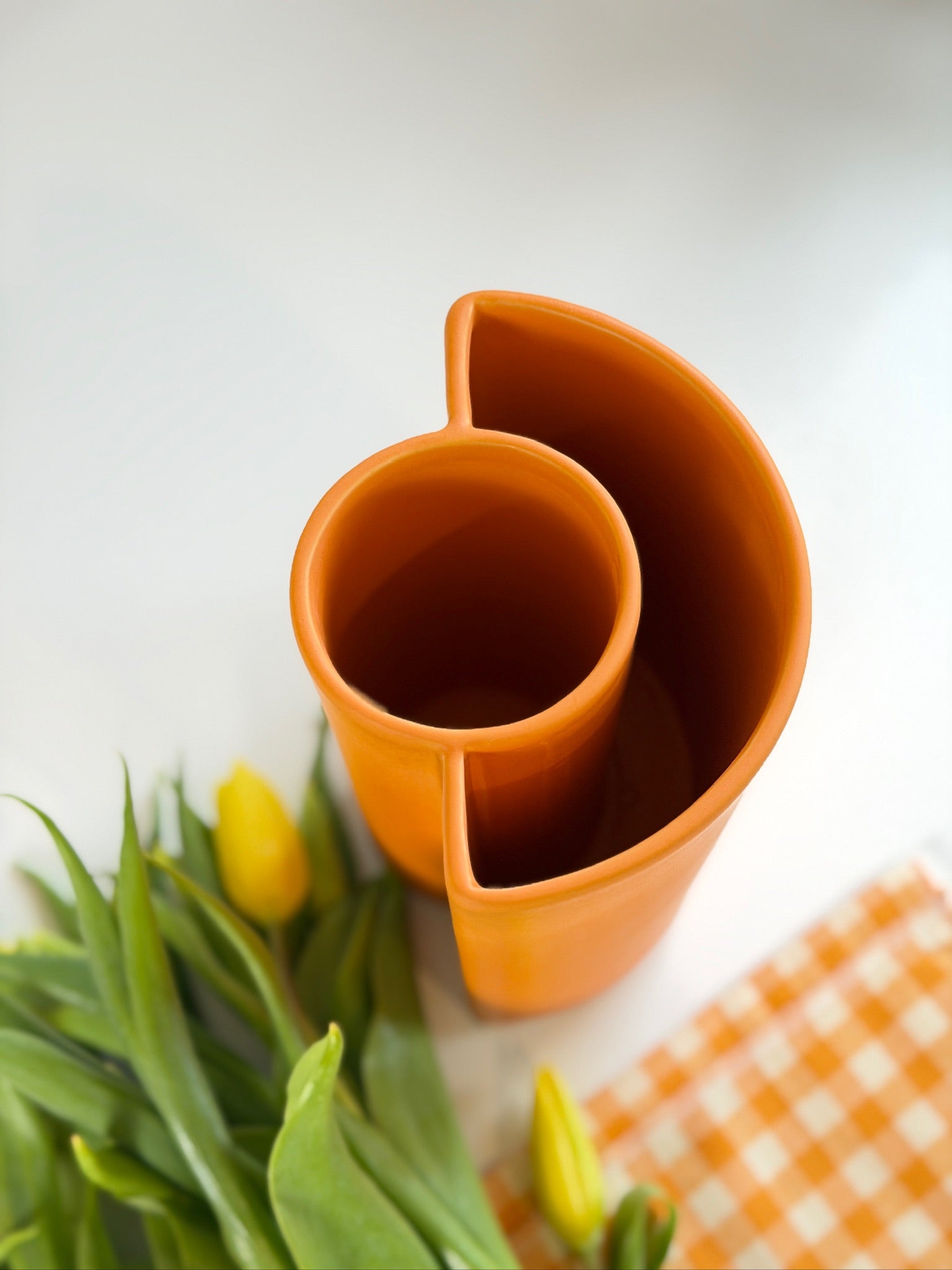 Orange ceramic vase with tulips on a white background