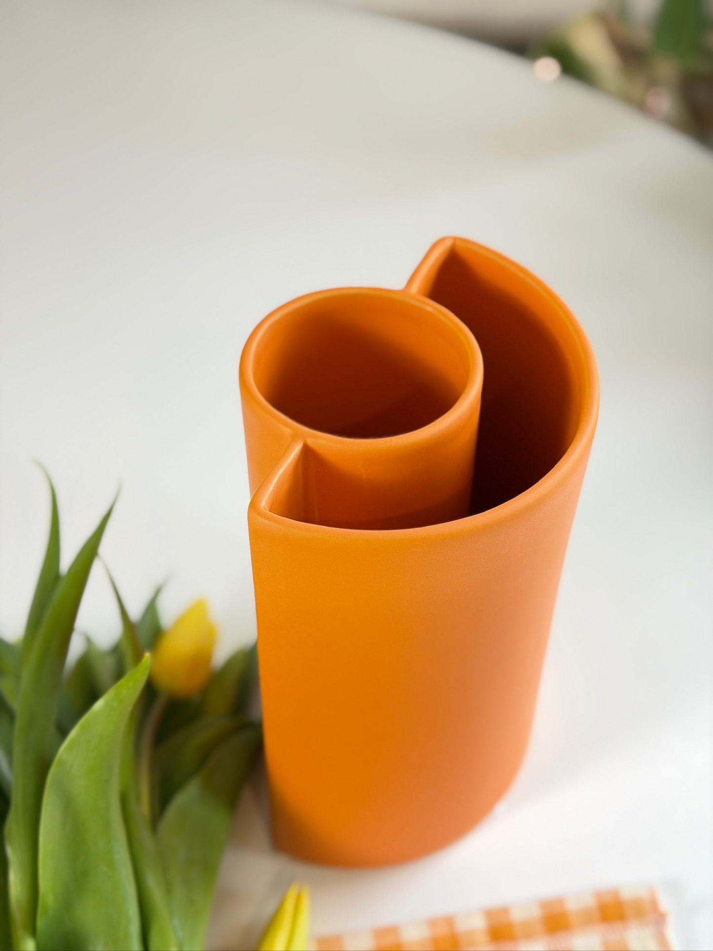 Orange Petal Ceramic Vase viewed from above showing the overlapping curled-petal opening, beside tulips.