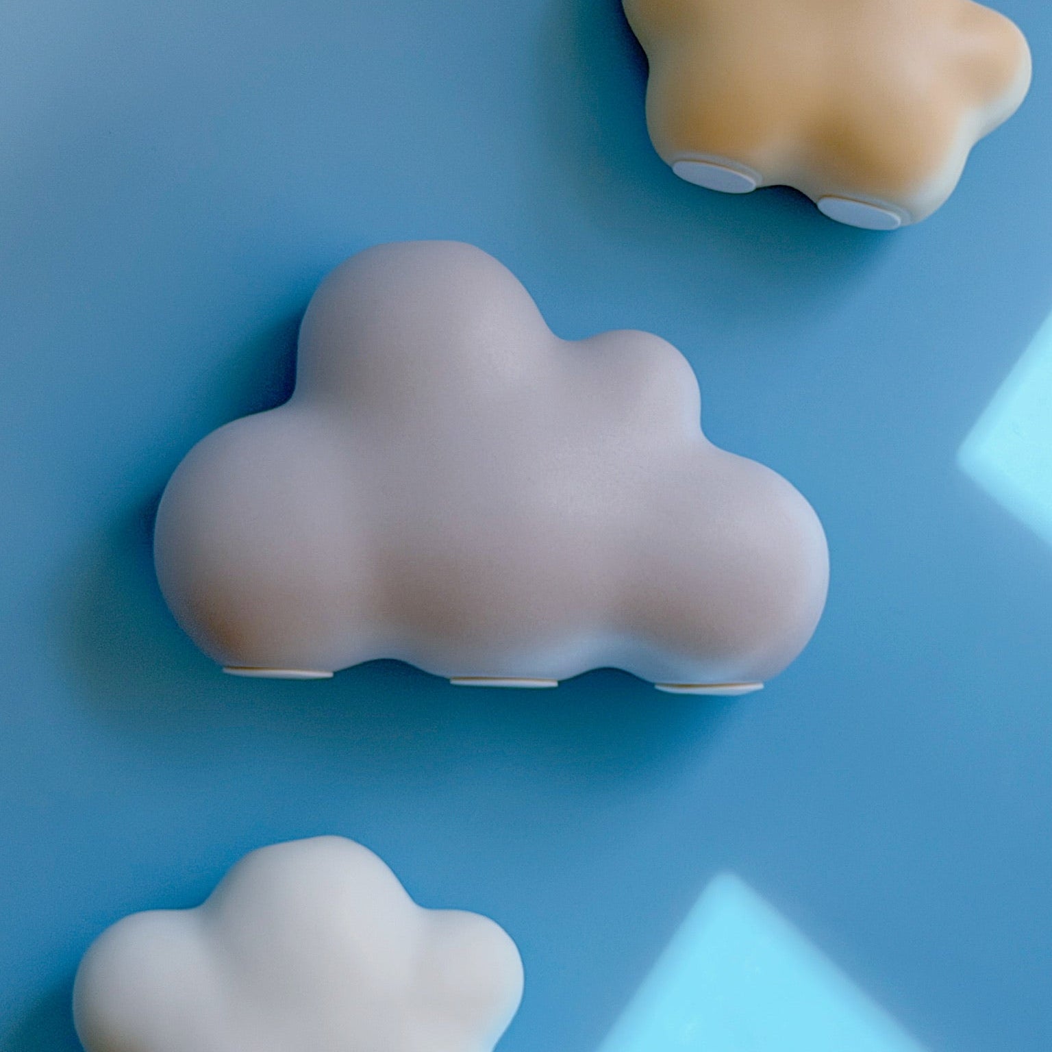 yellow, lavender, and white cloud bud vases on a blue blackground