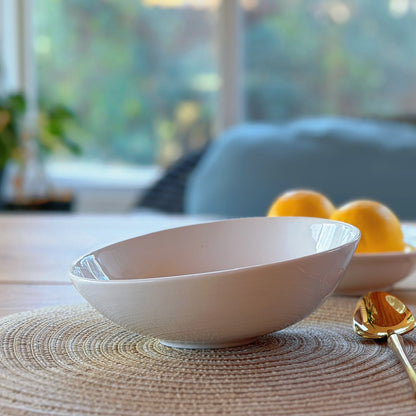 white asymmetrical bowl on a table with a blurred background