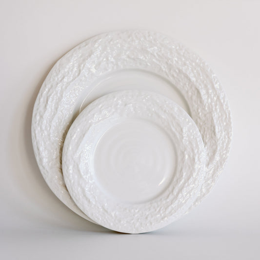 Two white Alpine Snow porcelain plates with rough textured rims stacked in two sizes against a soft white backdrop.