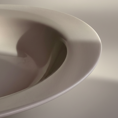Close-up of the asymmetric organic rim of a white Askew porcelain bowl.