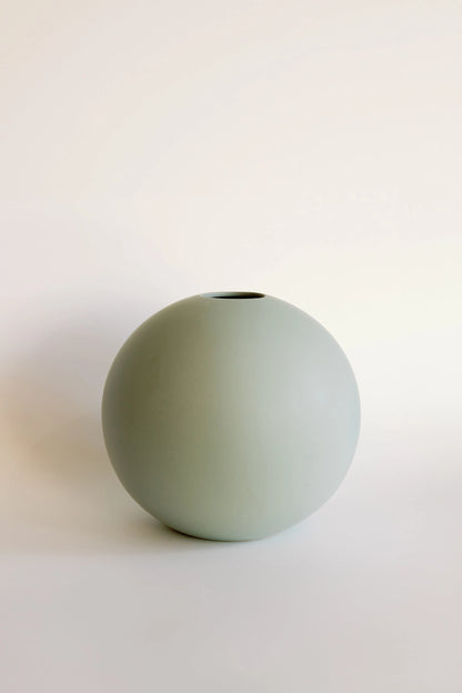 Ceramic orb bud vase in sage green, round sphere shape with small top opening and matte finish