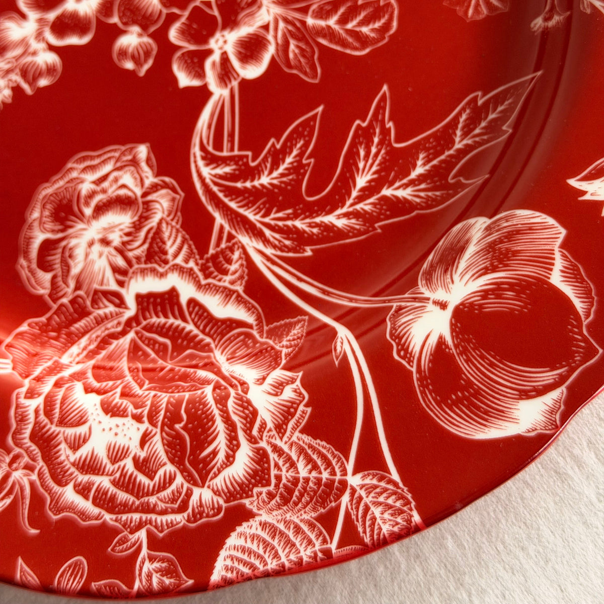 Close-up of white toile roses and blossoms on a deep red Cherry Chinoiserie porcelain dinner plate.
