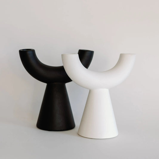 Crescent taper candle holders in black and white, twin U-shaped arms on cone bases, pair