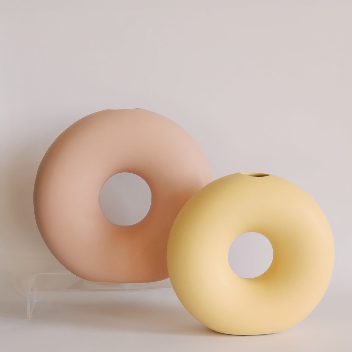 Two Donut ceramic bud vases in blush pink and pale yellow, matte ring shapes shown side by side.