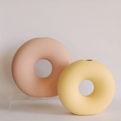 Two Donut ceramic bud vases in blush pink and pale yellow, matte ring shapes shown side by side.