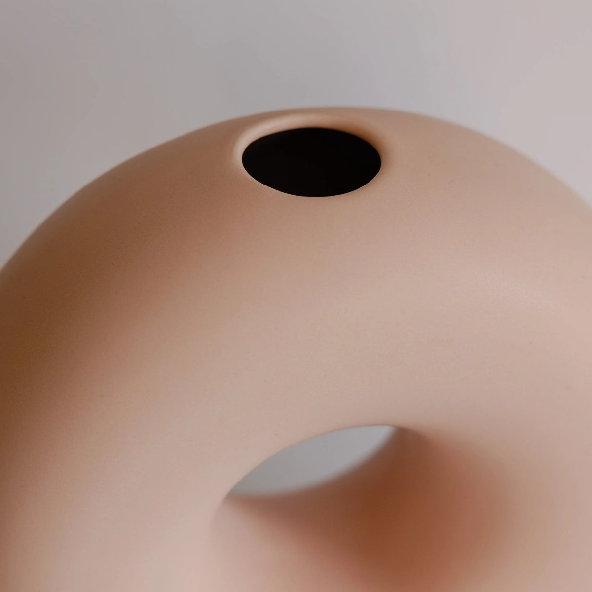 Peach donut bud vase close-up from above showing the small round opening at the top and matte ceramic surface