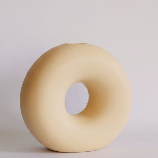Pale yellow Donut ceramic bud vase, matte ring shape with center hole and small top opening, single product.