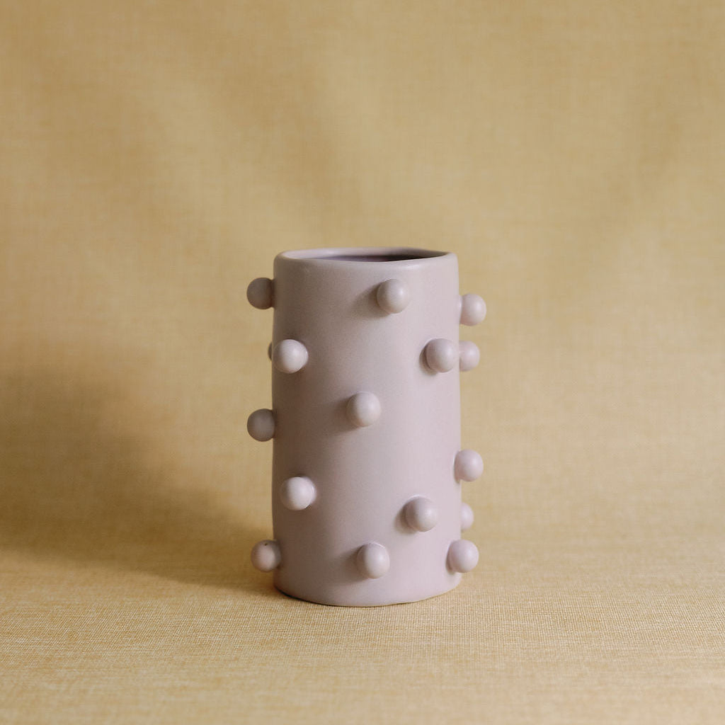Mauve Dotty Cylinder Ceramic Vase with raised dot studs, full view on a soft yellow linen backdrop.