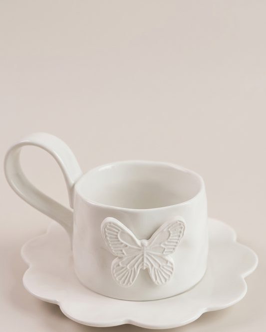 white mug with butterfly detail and matching saucer on white background