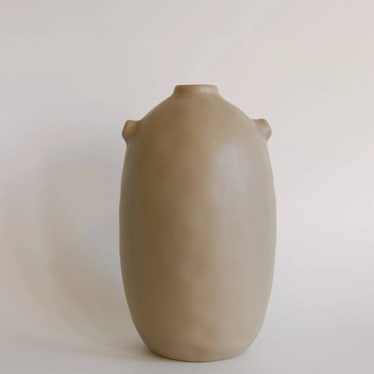 Single taupe Kiln ceramic vase, tall rounded body with narrow neck and two small side nubs, front view