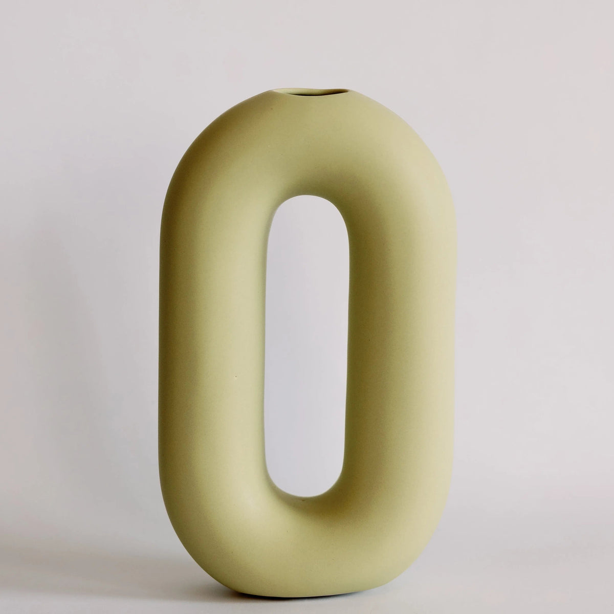 Olive green oval loop bud vase with elongated open center and small top opening, matte ceramic front view