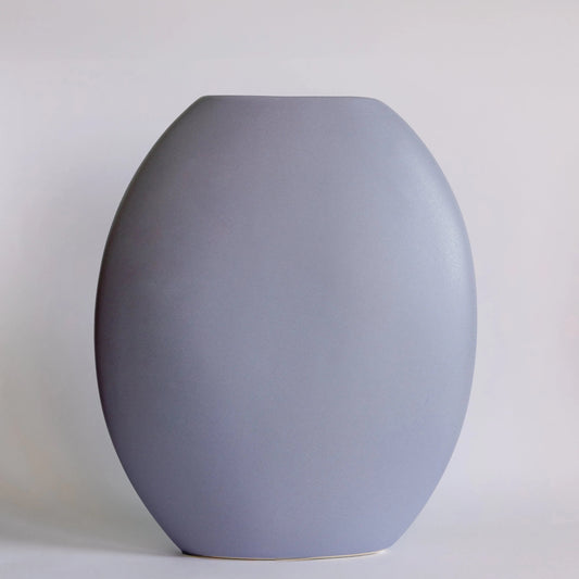 Pebble ceramic vase in matte periwinkle blue, rounded pebble-shaped body with flat top edge
