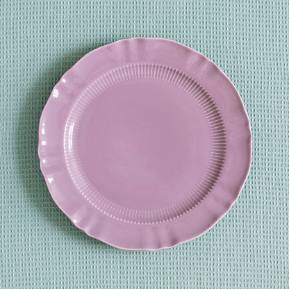Mauve Provence Pleated porcelain plate with ribbed band and scalloped edge on a pale green waffle cloth.
