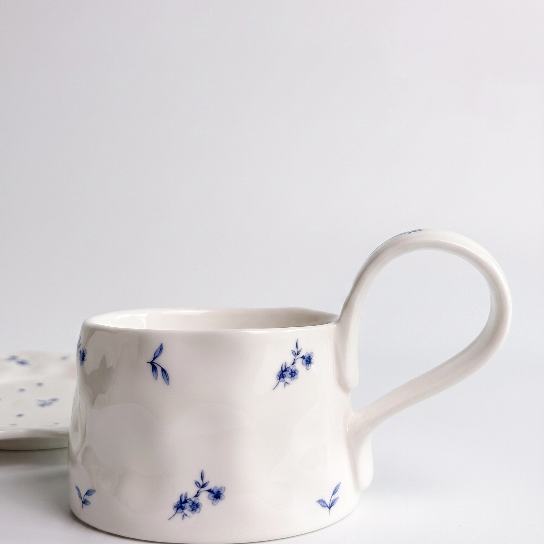 white mug with long handle and small blue flower print