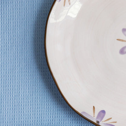 Two ceramic plates with floral designs on a blue textured surface