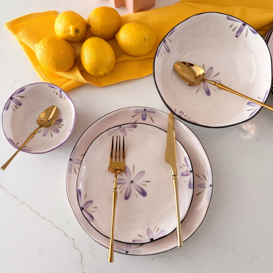 white and purple flower salad plate, dinner plate, serving bowl, and dessert bowl on marble white background