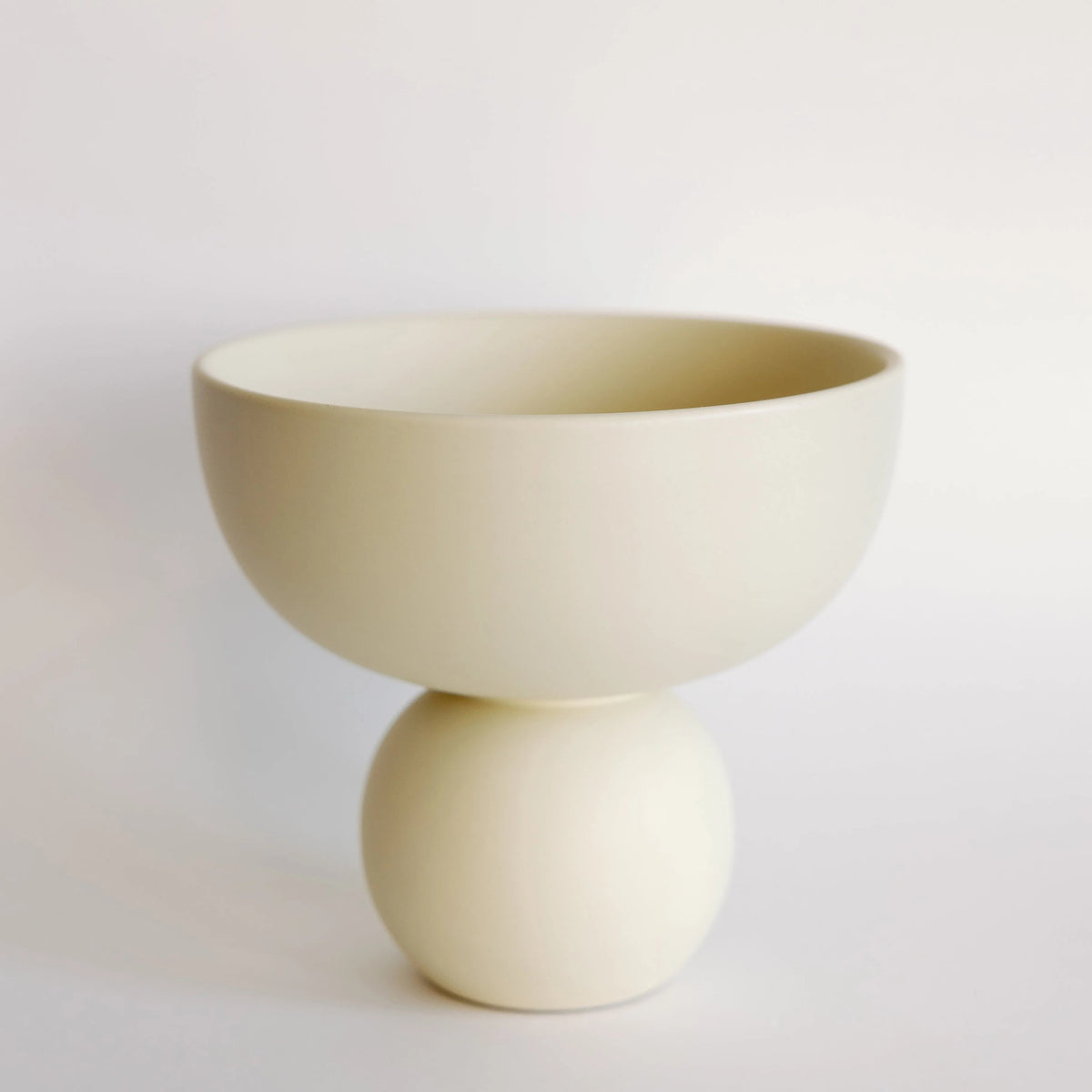 Sophie ceramic vase in cream, sculptural bowl shape resting on a round ball base, matte finish