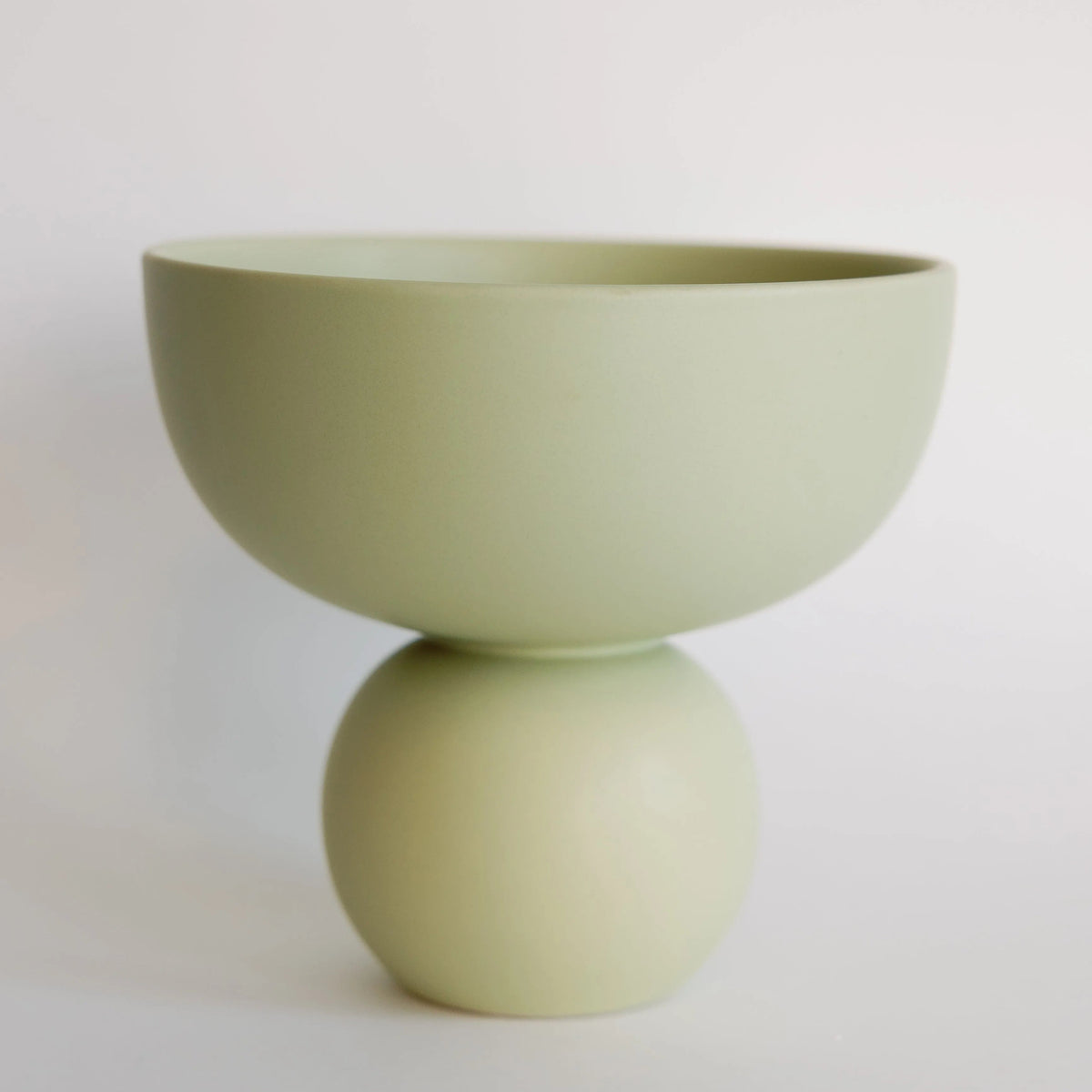 Sophie ceramic vase in sage green, matte bowl-on-sphere silhouette against a pale backdrop