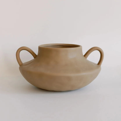 Tan matte stout amphora ceramic vase with two looped side handles, front view on neutral backdrop