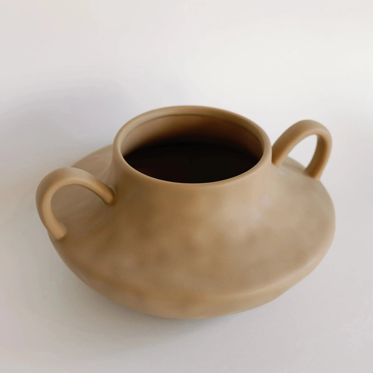 Tan stout amphora ceramic vase seen from above, showing wide mouth and dual handles on a low squat body